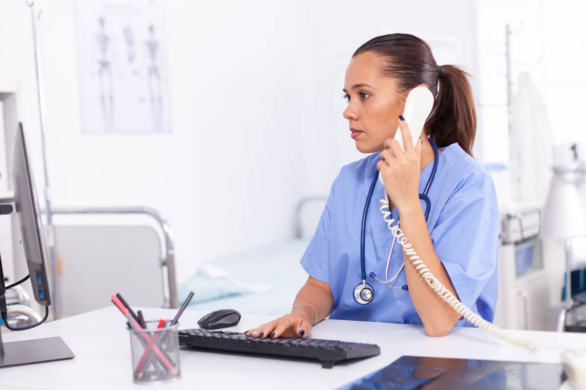 A nurse at a computer investigates reasons to report a nurse to the board of nursing.