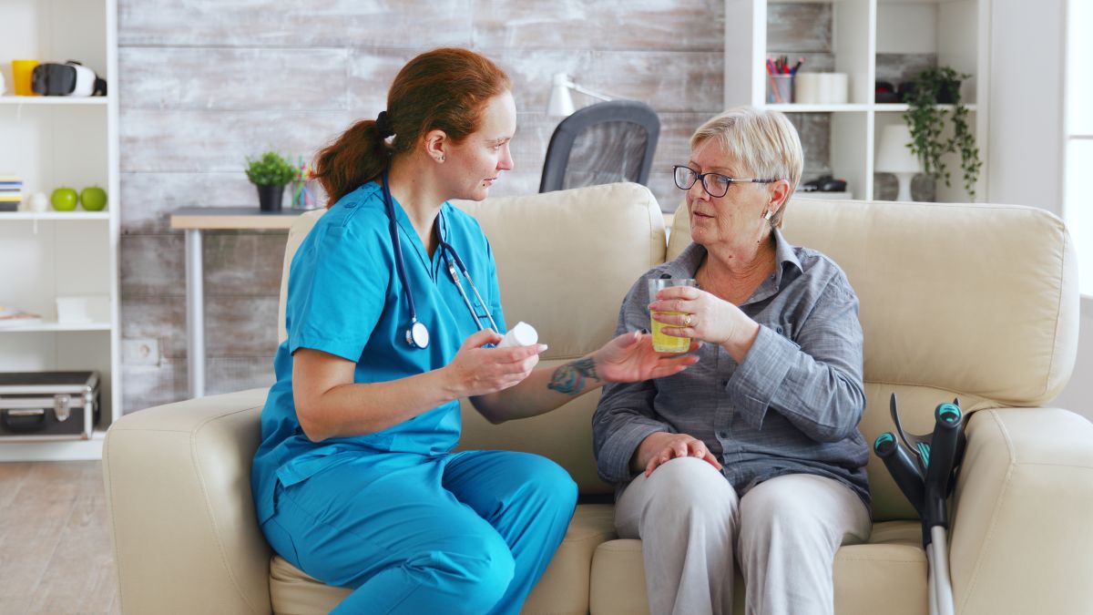 A nurse dispenses pills to a geriatric patient.