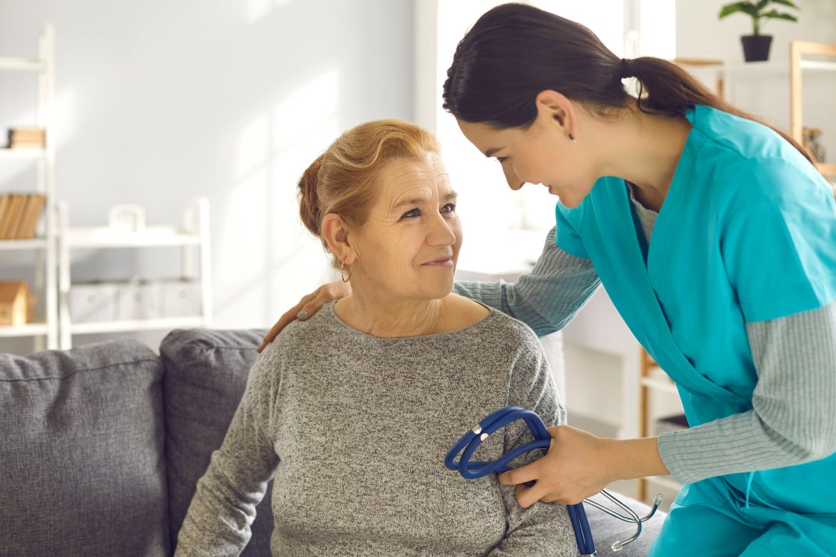 A cardiac nurse assists a patient.