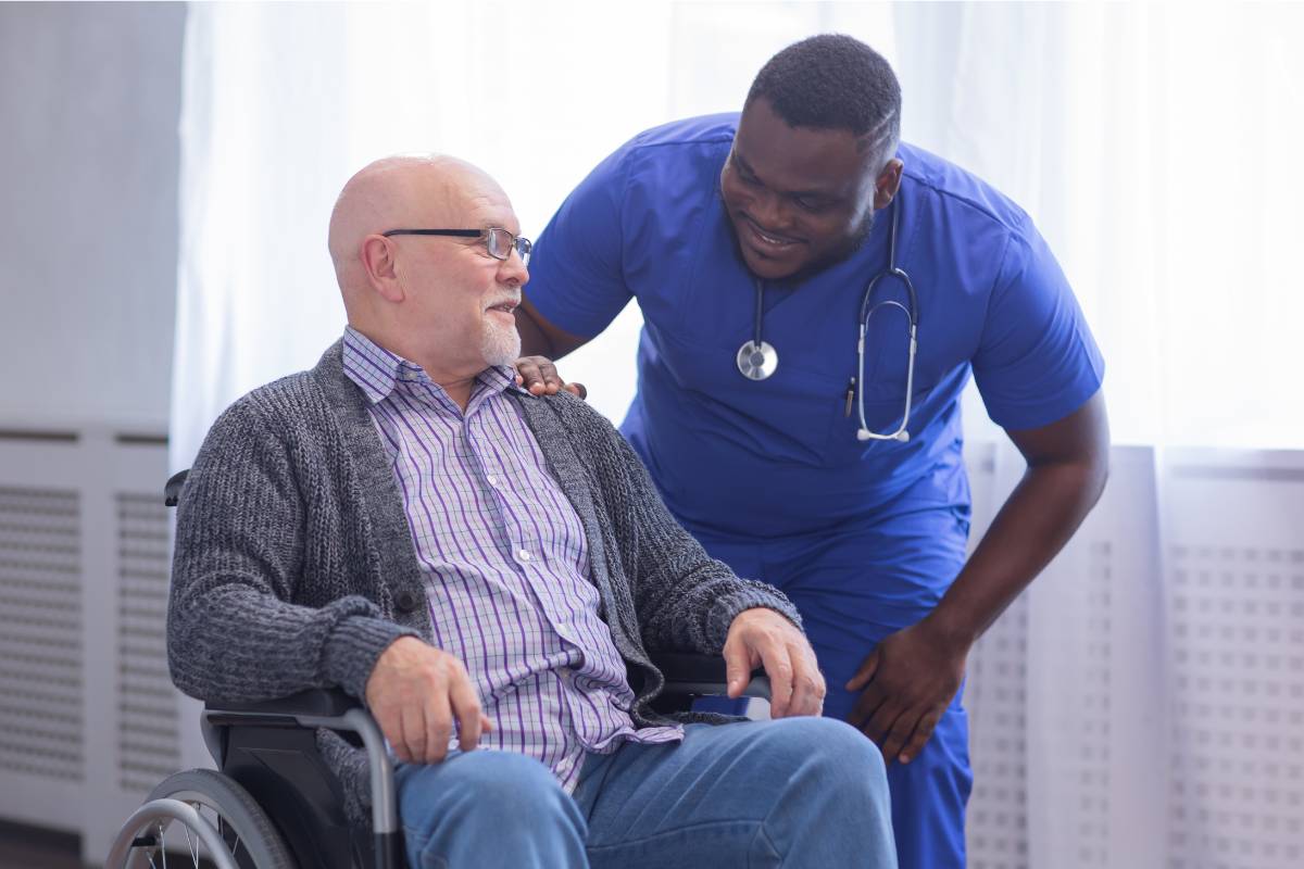 A nurse with CCCN certification converses with an elderly patient.