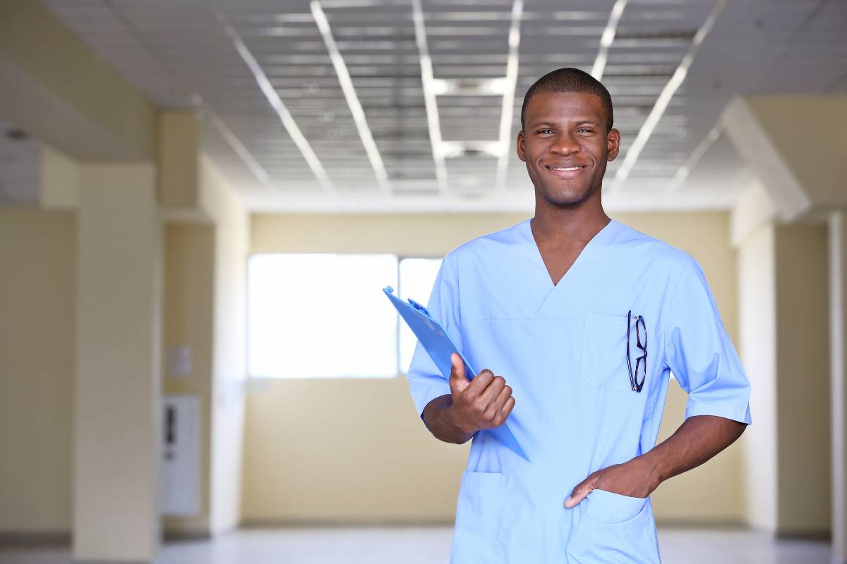 A nurse with COCN certification poses in a hospital hallway.