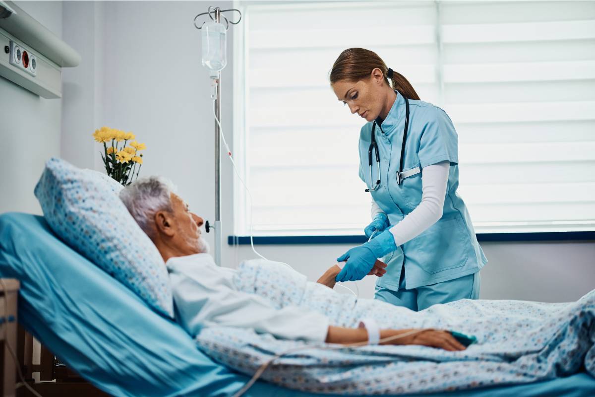 A nurse with CWOCN certification assists a patient in a hospital room.