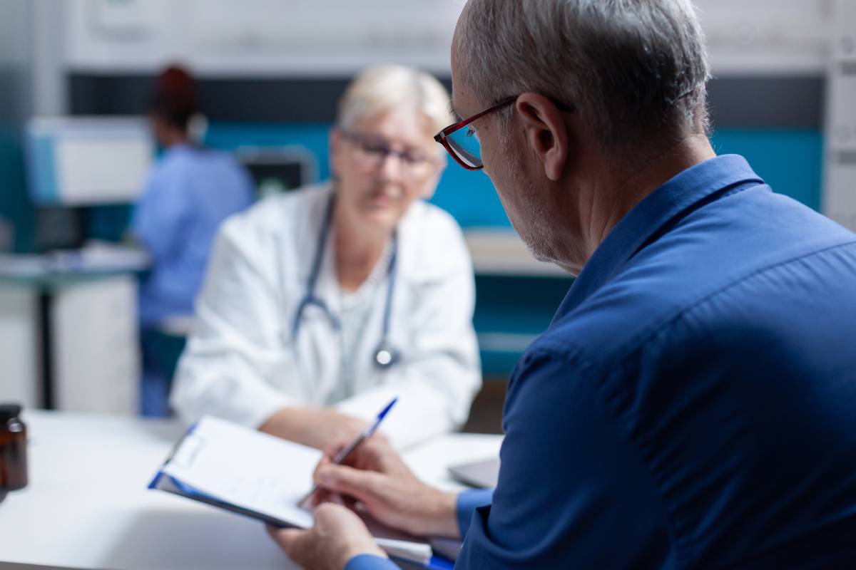 A patient signs a forma after learning about a nurse's role in informed consent.