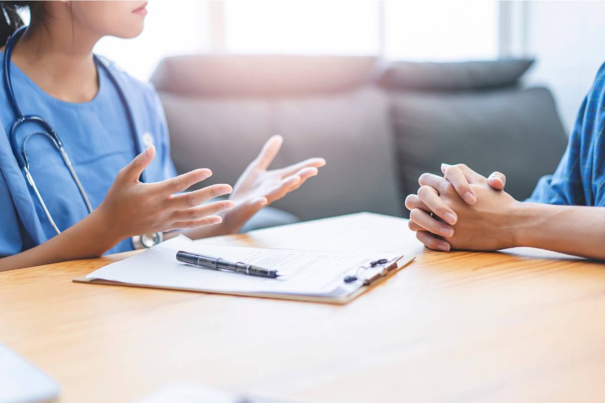 Two nurses discuss a nursing malpractice case at their facility.