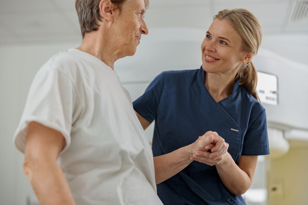 A patient care technician assists a patient.