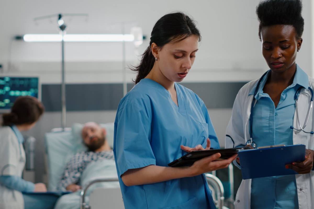 A nurse with PCCN certification discusses a patient with a doctor.