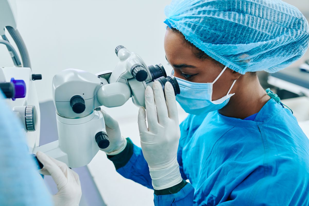 A research nurse looks through a microscope.