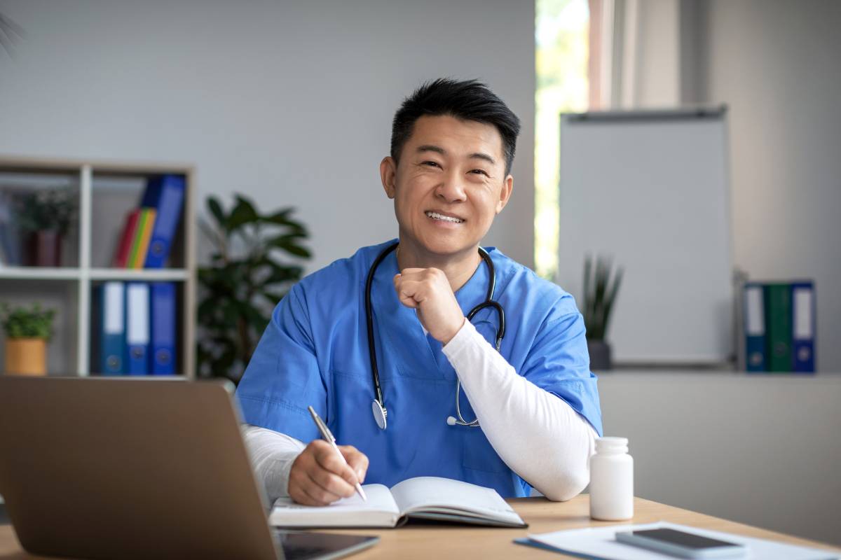 A nurse smiles while working on research for common tax deductions for nurses.