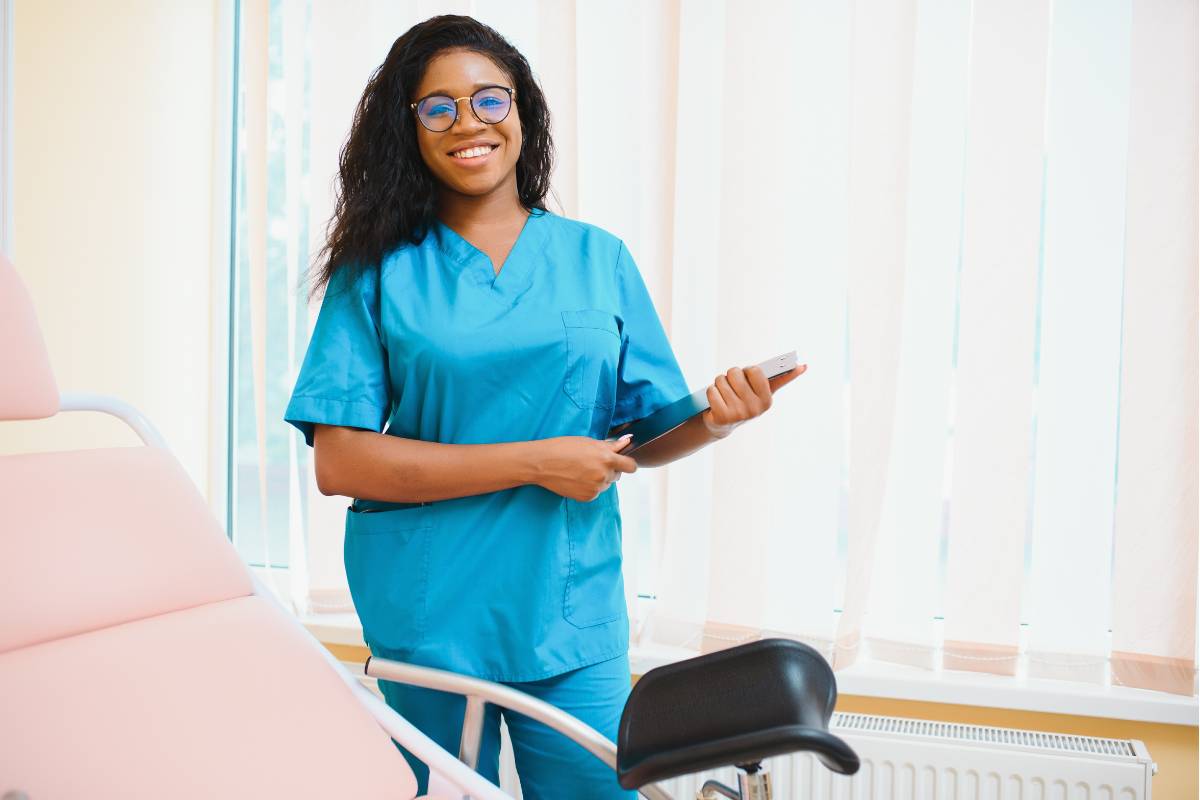 A nurse with CNRN certification stands in an exam room.