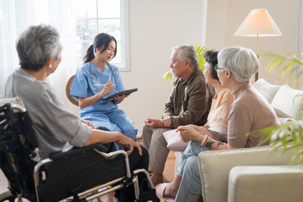 A community health nurse meets with a group of seniors at a long term care facility.