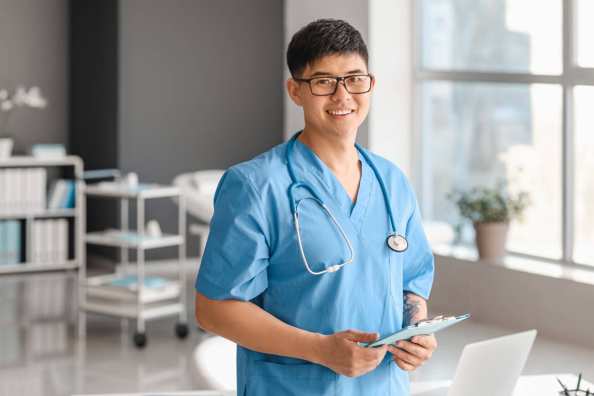 A MICU nurse poses for a photo in a hospital lobby.