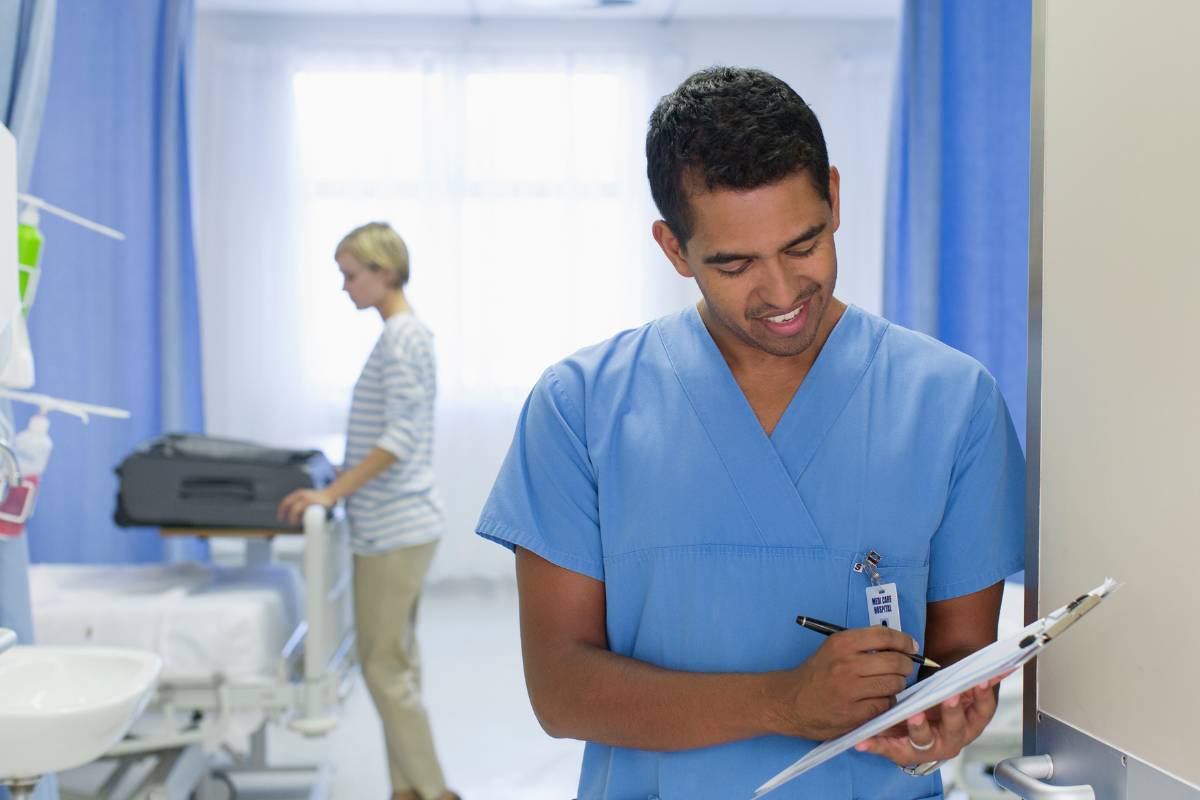 A nuclear medicine technologist, or nuclear med tech, records notes in a patient's file.