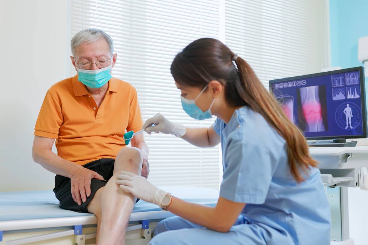 An orthopedic nurse practitioner assesses a patient's knee.