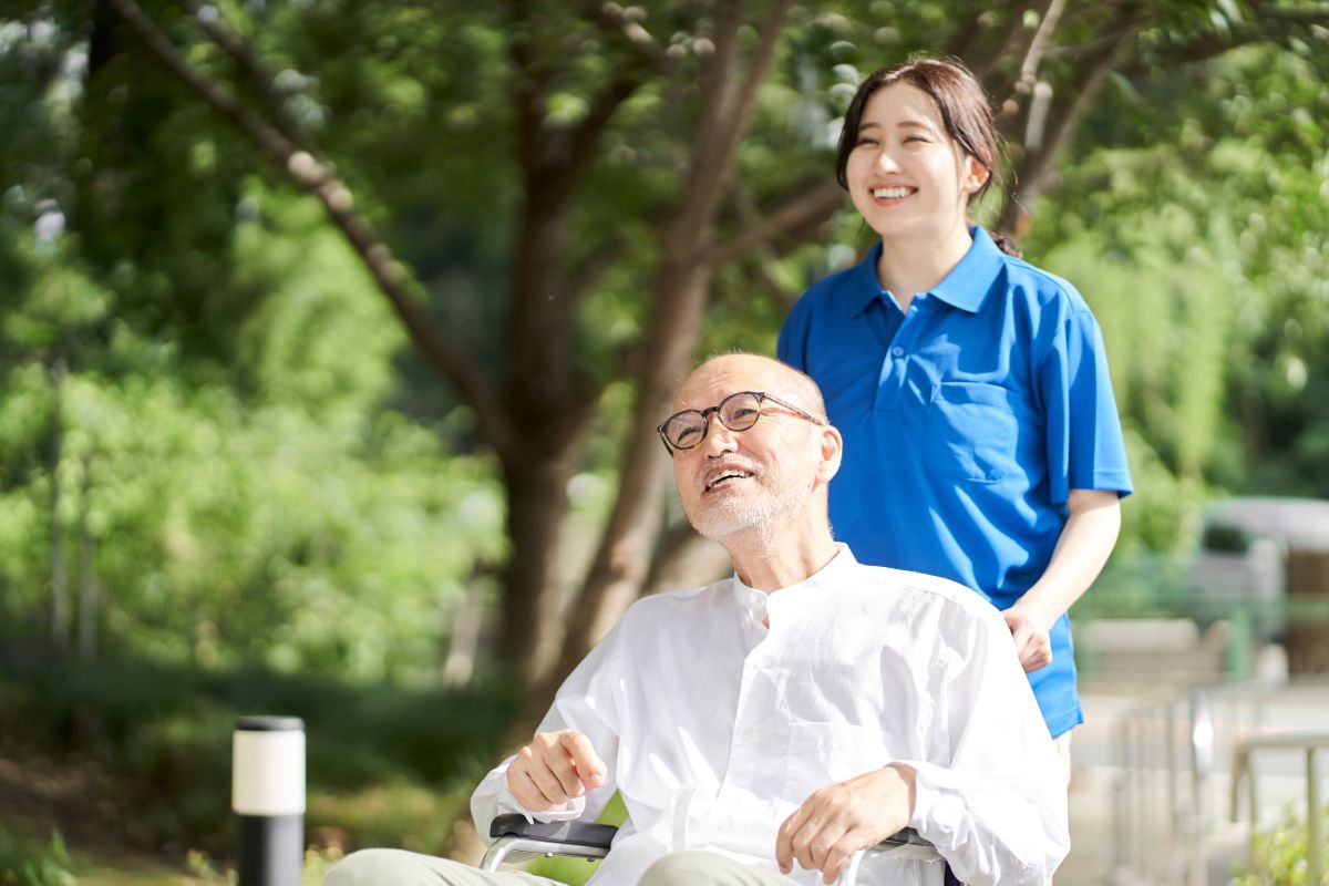 A patient care technician assists a wheelchair-bound patient.