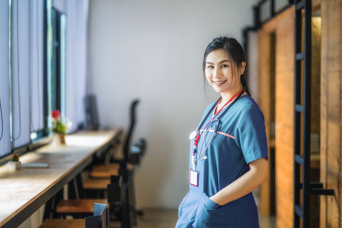 A nurse poses for a photo while answering the question the question, Can a new grad nurse be a travel nurse?